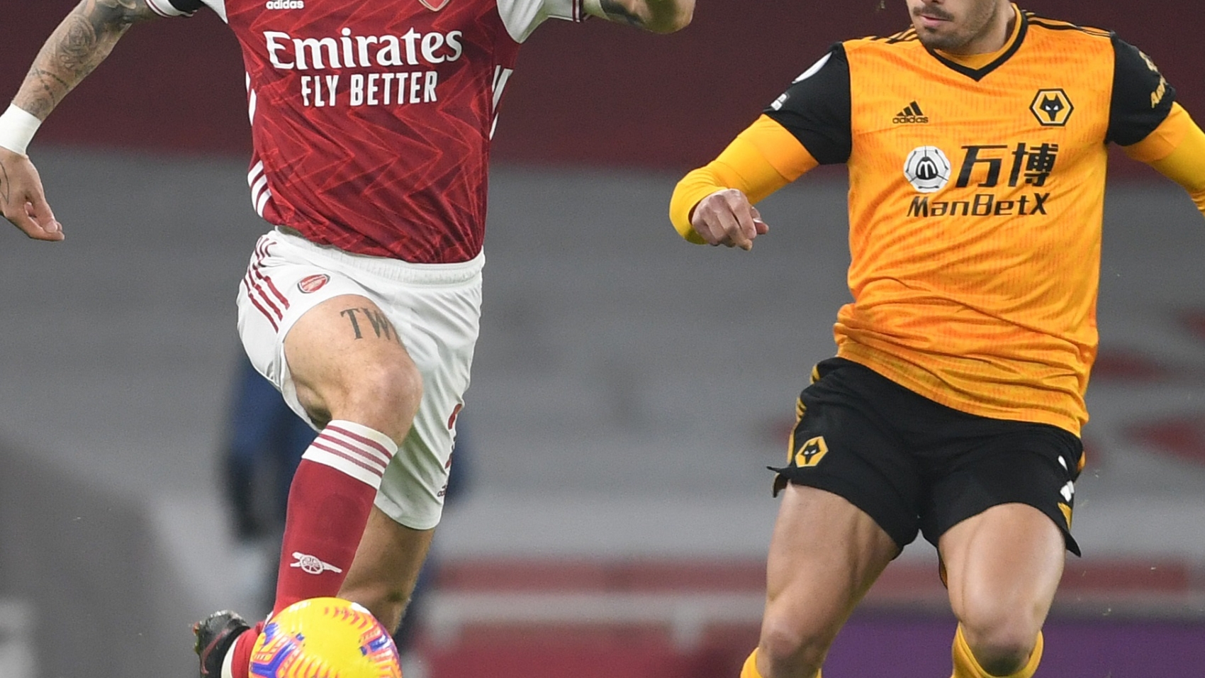 LONDON, ENGLAND - NOVEMBER 29: Hector Bellerin of Arsenal takes on Pedro Neto of Wolves during the Premier League match between Arsenal and Wolverhampton Wanderers at Emirates Stadium on November 29, 2020 in London, England. Sporting stadiums around the UK remain under strict restrictions due to the Coronavirus Pandemic as Government social distancing laws prohibit fans inside venues resulting in games being played behind closed doors. (Photo by David Price/Arsenal FC via Getty Images)